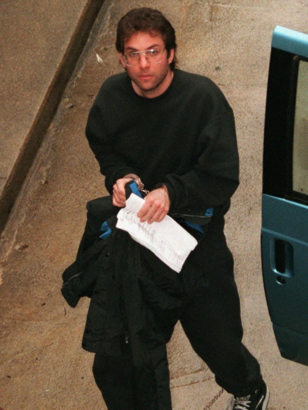 Kevin Mitnick komt in handboeien het Amerikaanse gerechtsgebouw binnen na zijn arrestatie. Illustratie: Herald Sun